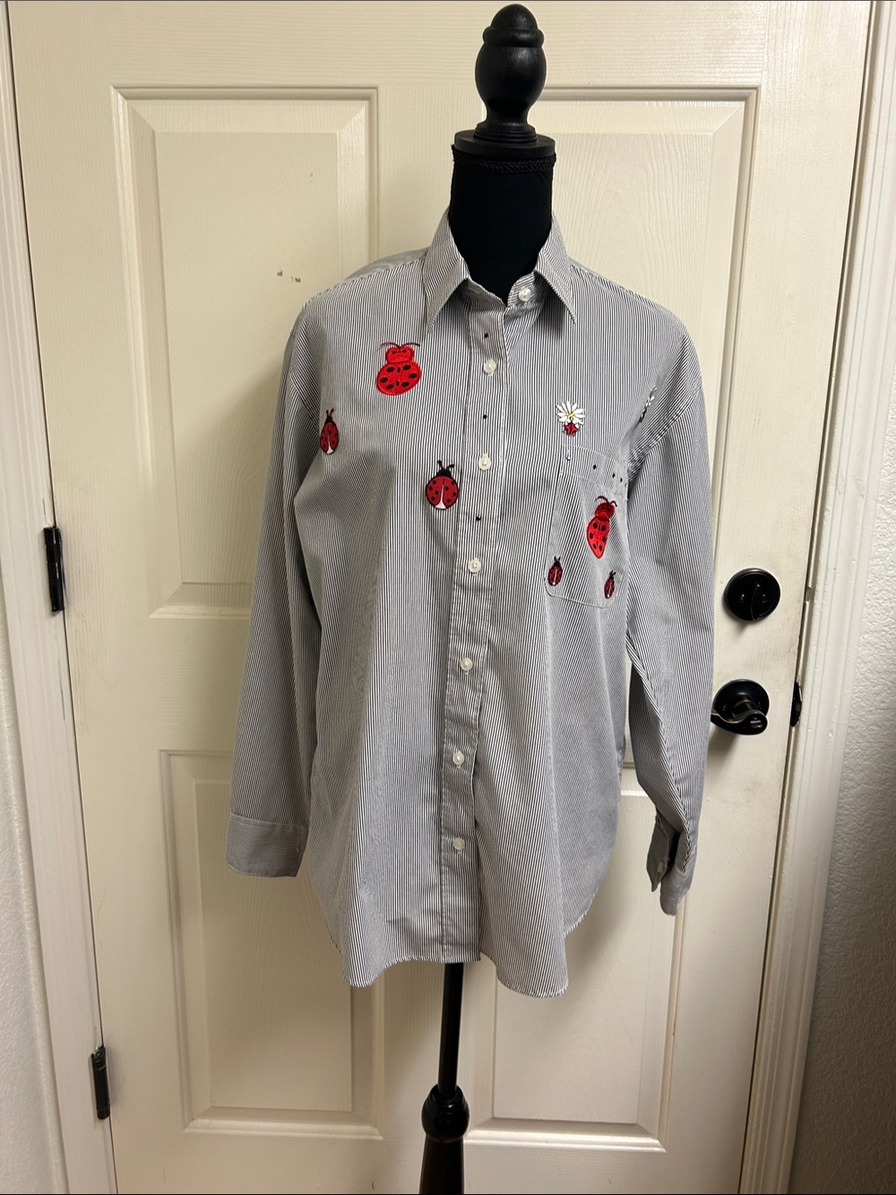 Las Olas black and white striped blouse features ladybug appliqués, Medium